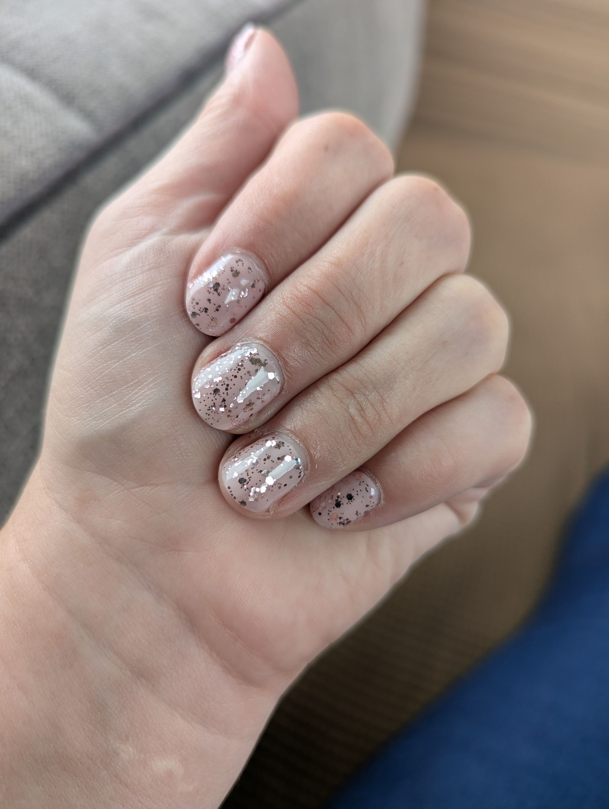 A finished soft pink manicure with a delicate glitter finish