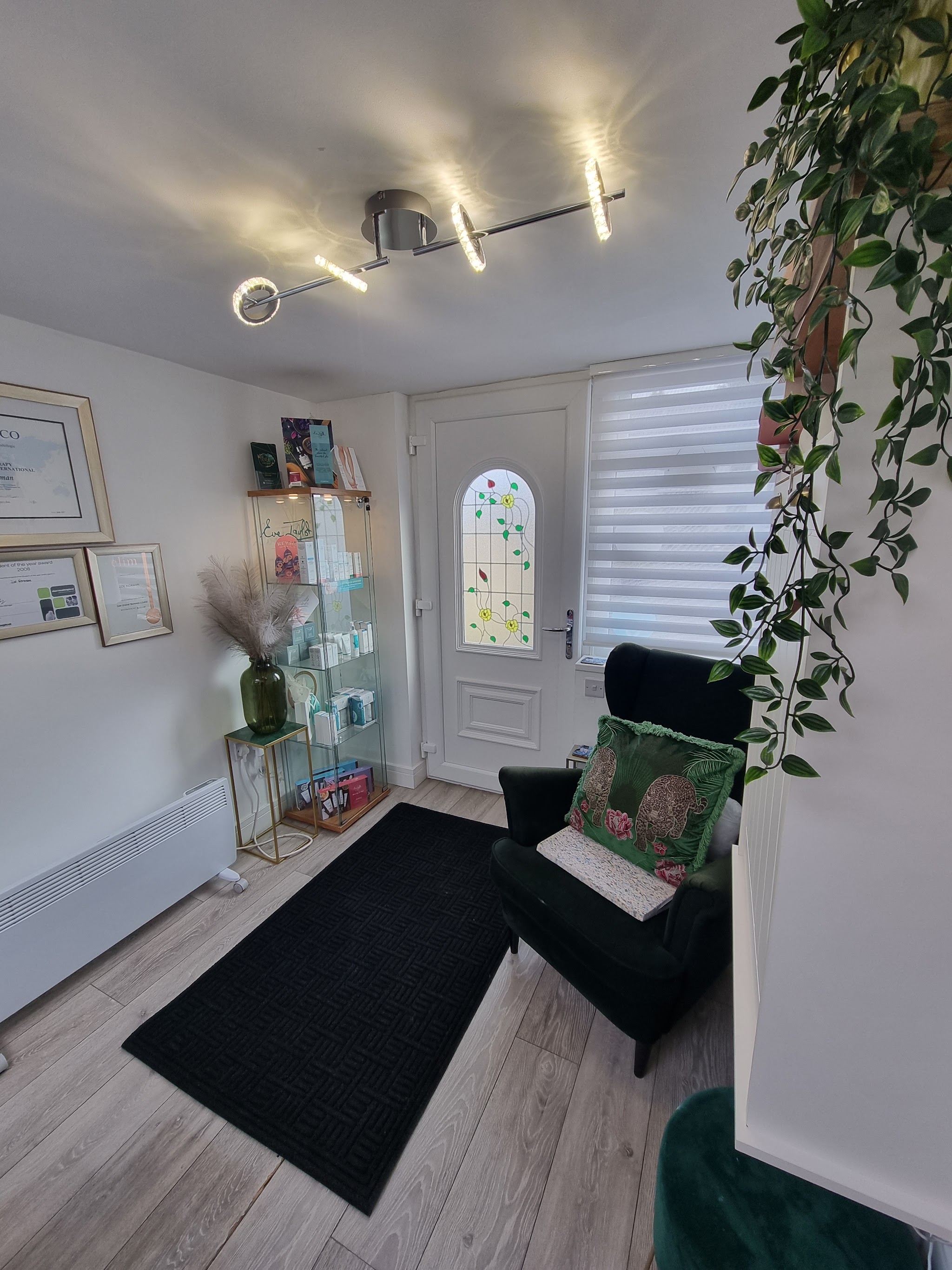 A green armchair, botanical details and skincare display inside Zoe's salon